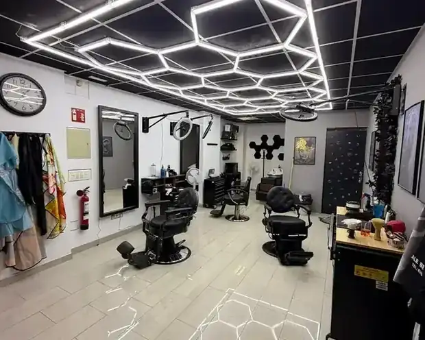Zona de barbería con sillones y espejos
